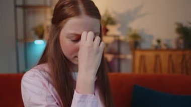 Gerilimden muzdarip çocuk serbest çalışan öğrencilerin yakın plan portresi, e-öğrenmeden sonra migain baş ağrısı, ev ofisinde oturan öğrencilerle uzaktan çalışma. Yetişkin kız iş kadını