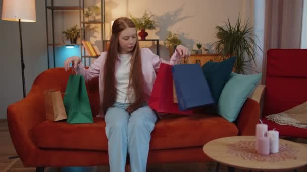 年轻的红头发小女孩快乐的购物狂消费者带着购物袋购物度假回来了 少女雀斑满足于在现代公寓从网上订购的邮包 — 图库视频影像