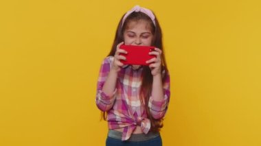 Endişeli, çocukluk çağındaki komik çocuk akıllı telefondan oyun oynuyor ya da video oyunu oynuyor. Heyecanlı küçük şirin çocuklar mobil telefon aygıtı kullanıyorlar. Sürücü simülatörlü.