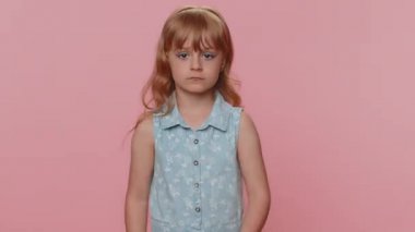 Aggressive preteen child girl kid making fight threat at camera, shaking fist punch, boxing with expression, punishment practicing exercises negative rage. Little toddler children on pink background