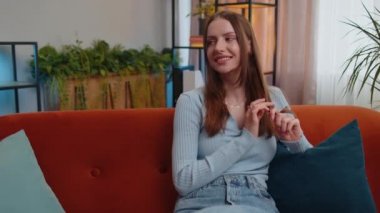 Portrait of happy calm young woman smiling friendly glad expression looking away dreaming resting, relaxation feel satisfied concept good news sitting on sofa at home room. Pretty girl falling in love