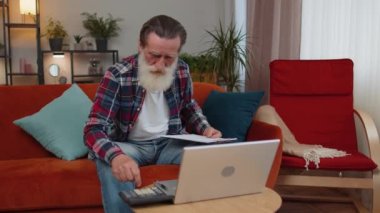 Büyükbaba, muhasebe ödemeleri ve aylık harcamaları hesaplıyor. Banka faturalarını hesaplıyor. Ev odasındaki kanepenin evrak işlerini inceliyor. Emekli emekli emekli serbest çalışan bilgisayarlı uzaktan kumanda işinde çalışıyor.