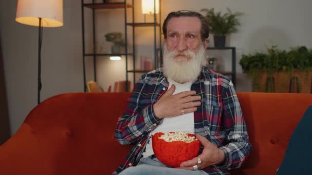 Excited Senior Old Grandfather Sitting Sofa Eating Popcorn Watching Interesting — Video Stock