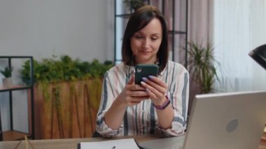 Young businesswoman working smartphone online, show like thumbs up, remote distance job education, working from home office. Girl freelancer study, e-learning, texting messages content on social media