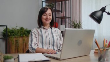 Young woman freelancer sitting at home office desk making video call chat conversation conference use laptop. Adult girl student study working online remote distance job, talking, briefing by webcam