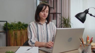 Tired woman freelancer suffering from tension, migaine headache sitting at desk at home office, closing eyes meditating with concentrated thoughts, peaceful mind. Girl student study working online