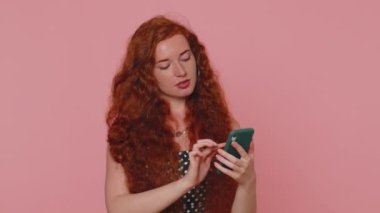 Güzel kızıl saçlı kadın cep telefonu kullanıyor. İnternet mesajlarında yeni mesajlar yazıyor. Sosyal ağların bağımlılığını araştırıyor. Kızıl saçlı genç kız stüdyoda çekildi. Pembe duvarda tek başına.