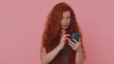 Mutsuz, üzgün, genç, kızıl saçlı bir kadın akıllı telefon daktilo kullanıyor. Ani piyango sonuçlarını kaybediyor. Kötü talih, kayıp, şanssız haber. Pembe stüdyo geçmişinde çilli kızıl kız.