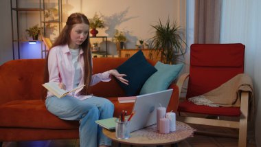 Çocuk öğrenci, evde dizüstü bilgisayarla kitap okuyarak serbest çalışıyor. Genç bir çocuk web kamerasıyla konuşurken görüntülü konuşma yapıyor. Çevrimiçi öğretmen uzaktan sohbette e-öğreniyor. Çevrimiçi uzaktan eğitim