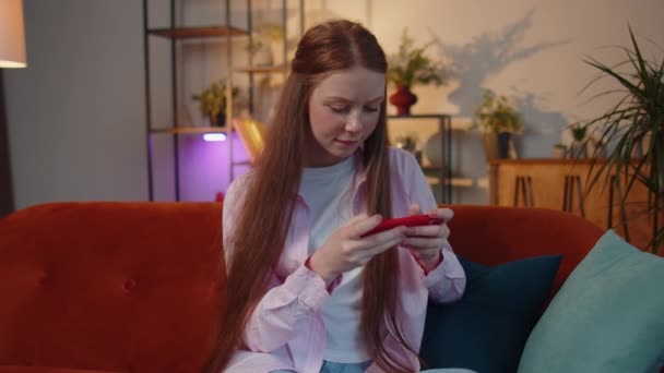 Endişeli Genç Kızıl Saçlı Kız Çocuk Cep Telefonuyla Video Oyunu — Stok video