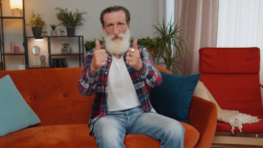 İyi iş çıkardın. Yaşlı büyükbaba onaylıyor ve onaylıyor, başarılı bir iş çıkarıyor, modern bir evde tatmin oluyor. Emekli yaşlı emekliler kanepede oturuyor.