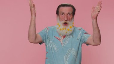 Oh my God, Wow. Excited amazed winner elderly man 60s raising hands in surprise looking at camera with big eyes shocked by sudden victory. Sincere senior grandfather isolated on pink studio background