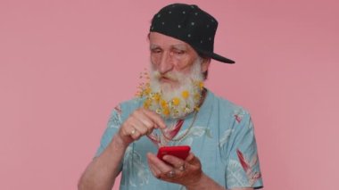 Senior man flowered beard using smartphone typing new post on web, browsing, searching, addiction of social networks, show thumbs up like, positive feedback, recommends wifi cellular connection 5G