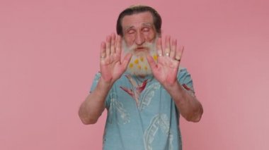 No stop. Serious man say no, hold palm folded crossed hands in stop danger gesture, warning of finish, prohibited access, declining communication, body language. Senior grandfather on pink background