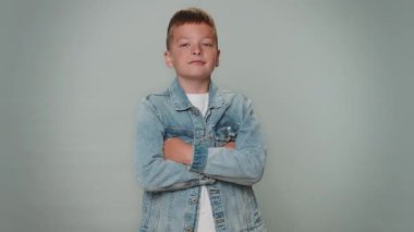 Sevimli, neşeli çocuk önerini çok beğendi. Başını sallıyor, güzel bir işten memnun, evlenme teklifi gibi. Gri stüdyo arka planında izole edilmiş küçük çocuklar.