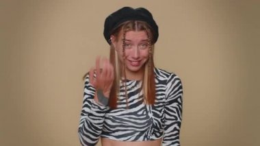 Sen delisin, aklın yerinde değil. Güzel, genç bir kadın kamerayı işaret edip aptalca bir jest yapıyor ve bir aptalı delice bir plan için suçluyor. Bej renkli stüdyo arka planında izole edilmiş yetişkin tarzı bir kız.