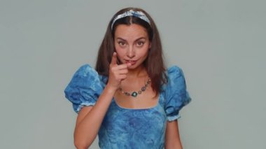 Upset displeased young woman shakes finger and saying no, be careful, scolding and giving advice to avoid danger mistake, disapproval sign. Adult stylish girl isolated on gray studio background