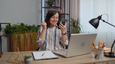 Kazanan genç bayan serbest çalışan cep telefonlu daktilo kullanıyor ve 