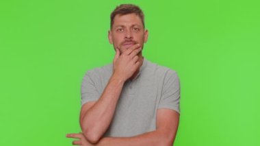 Bearded young man feeling hopelessness and loneliness, nervous breakdown, loses becoming surprised by lottery results, bad fortune, loss, unlucky news. Adult guy on green chroma key studio background