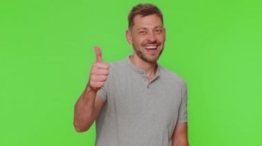 Like. Bearded handsome young man raises thumbs up agrees with something or gives positive reply recommends advertisement likes good. Adult guy isolated alone on chroma key studio background indoors