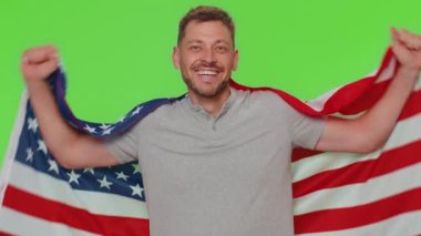 Amerikan bayrağını sallayan ve saran sakallı genç adam, insan hakları ve özgürlüklerini kutluyor. Bağımsızlık Günü. Yetişkin adam yeşil krom anahtar stüdyo arka planında tek başına kapalı.