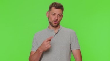 Seni seçiyorum. Yakışıklı genç adam kamerayı işaret ediyor ve neşeli bir ifadeyle bakıyor, seçim yapıyor, yön gösteriyor. Yetişkin adam krom anahtar stüdyo arka planında tek başına kapalı.