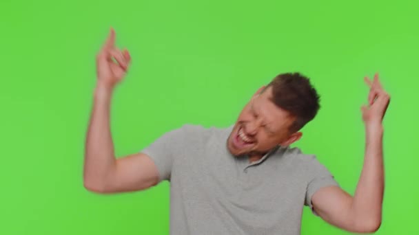 Overjoyed delighted handsome man showing rock n roll gesture by hands, cool sign, shouting yeah with crazy expression, dancing, emotionally rejoicing in success. Adult guy on chroma key background