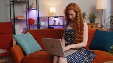 Puantiyeli kızıl saçlı genç bir kadın evde oturma odasında serbest giyiniyor kanepeye oturuyor ve dizüstü bilgisayarını açıyor. Kızıl kız defterde çalışıyor, mesajlar gönderiyor, online alışverişler yapıyor, film izliyor.