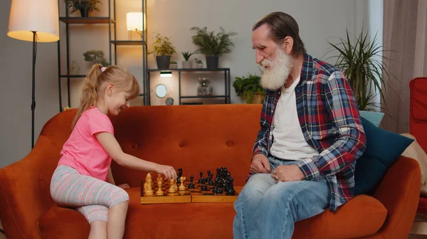 Smiling Senior Old Grandfather Man Playing Chess Teen Granddaughter Home — Zdjęcie stockowe
