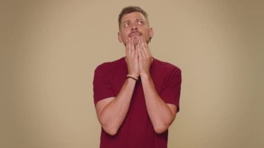 I dont know what to say. Confused handsome young man feeling embarrassed about ambiguous question, having doubts, no idea, being clueless and uncertain. Adult stylish guy on beige studio background