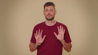 I am not guilty. Puzzled guilty young man pointing fingers hisself ask say who me no thanks i do not need it, refusal. Adult stylish male guy isolated alone on beige studio wall background indoors