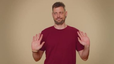 I am dont want it, not me. Confused upset young man pointing fingers hisself ask say who why me no thanks i do not need it, rejection, refusal, stop sign. Adult stylish guy on beige background
