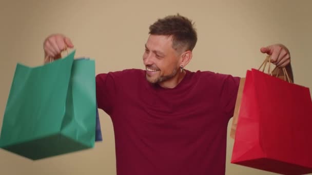 Happy Young Man Showing Shopping Bags Advertising Discounts Smiling Looking — Video