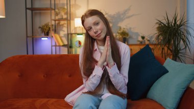 Lütfen, Tanrım yardım et. Genç kızıl saçlı kız kollarını kavuşturarak dua ediyor, yukarı bakıyor ve dilek tutuyor, umut dolu bir ifadeyle soruyor, özür diliyor. Evde çilli bir çocuk var.