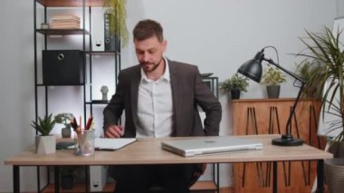 Businessman freelancer in suit enters office workplace, working on laptop computer at desk. Professional manager freelancer man works on notebook, sends messages makes online purchases watching movies