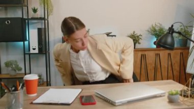 Businesswoman freelancer enters office start working on laptop computer at desk and drinking morning coffee. Woman works on notebook, sends messages makes online purchases watching social media movies