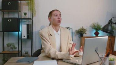Businesswoman working on laptop computer, meditating, doing yoga breathing exercise in lotus position at home office desk. Calm serene freelancer woman taking break. Busy occupation. Peace of mind