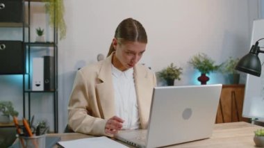 Like. Happy business woman in suit working on laptop looking approvingly at camera showing thumbs up, like sign positive something good, positive feedback at office workplace desk. Freelancer girl
