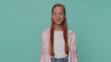Hey you. Lovely pretty teenager girl smiling excitedly and pointing to camera, choosing lucky winner, indicating to awesome you. Young teen child kid isolated alone on blue studio background indoors