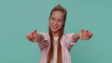 Come to me, I want to embrace you. Pretty teenager girl spread hands and give hug to you. Pleasant expression, love feelings. Young female child kid isolated alone on blue studio background indoors