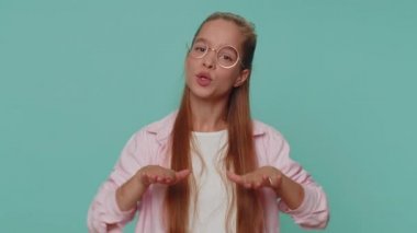 Hey you, be careful. Teenager girl warning with admonishing finger gesture, saying no, be careful, scolding and giving advice to avoid danger, disapproval sign. Young teen child kid on blue background