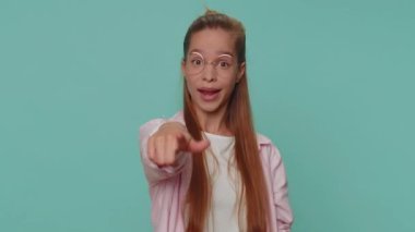 Call me, here is contact number. Lovely pretty teenager girl looking at camera doing phone gesture like says hey you call me back. Young female child kid isolated on blue studio background indoors