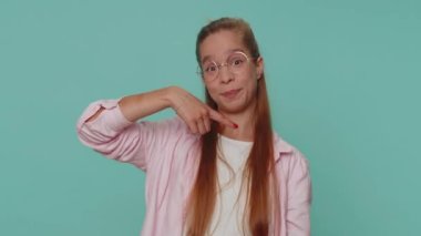 Look at advertisement. Lovely pretty teenager girl pointing down, saying to subscribe, gesturing ok and like, showing place for commercial, promotional information below. Child kid on blue background