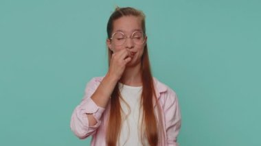 I will not say anyone. Frightened teen girl closing her mouth with hand, looking intimidated scared at camera, gestures no, refusing to tell terrible secret, unbelievable truth. Young female child kid