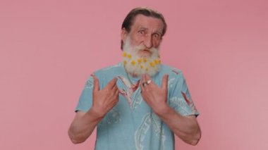 I am the best, choose me. Senior man with flowers in gray-haired beard feeling very proud pointing himself, looking self-confident, overjoyed by success. Elderly grandfather on pink studio background