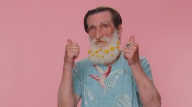 Great job, nice. Cheerful positive happy senior man showing thumbs up and nodding in approval, successful good work. Elderly stylish one grandfather on pink studio background. People sincere emotions