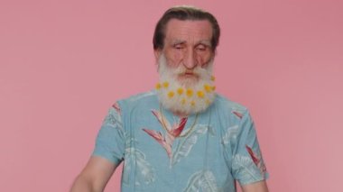 Look at advertisement. Senior man pointing down, saying to subscribe, gesturing ok and like, showing place for commercial, promotional information below. Elderly grandfather on pink studio background