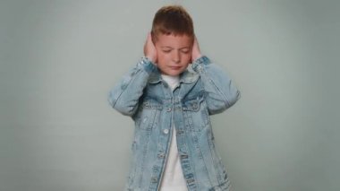 Dont want to hear and listen. Frustrated annoyed irritated toddler boy covering ears, gesturing no, avoiding advice ignoring unpleasant noise loud voices. Young children child kid on gray background