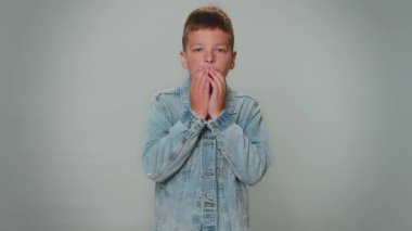 Offended toddler boy kid in jacket having misunderstanding, frustrated after quarrel, ignores and does not want to communicate, talk. Young children teenager. Child isolated on gray studio background