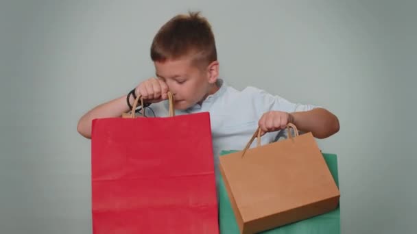 Хлопчик Показує Рекламні Знижки Торгових Сумках Посміхається Виглядаючи Враженим Низькими — стокове відео